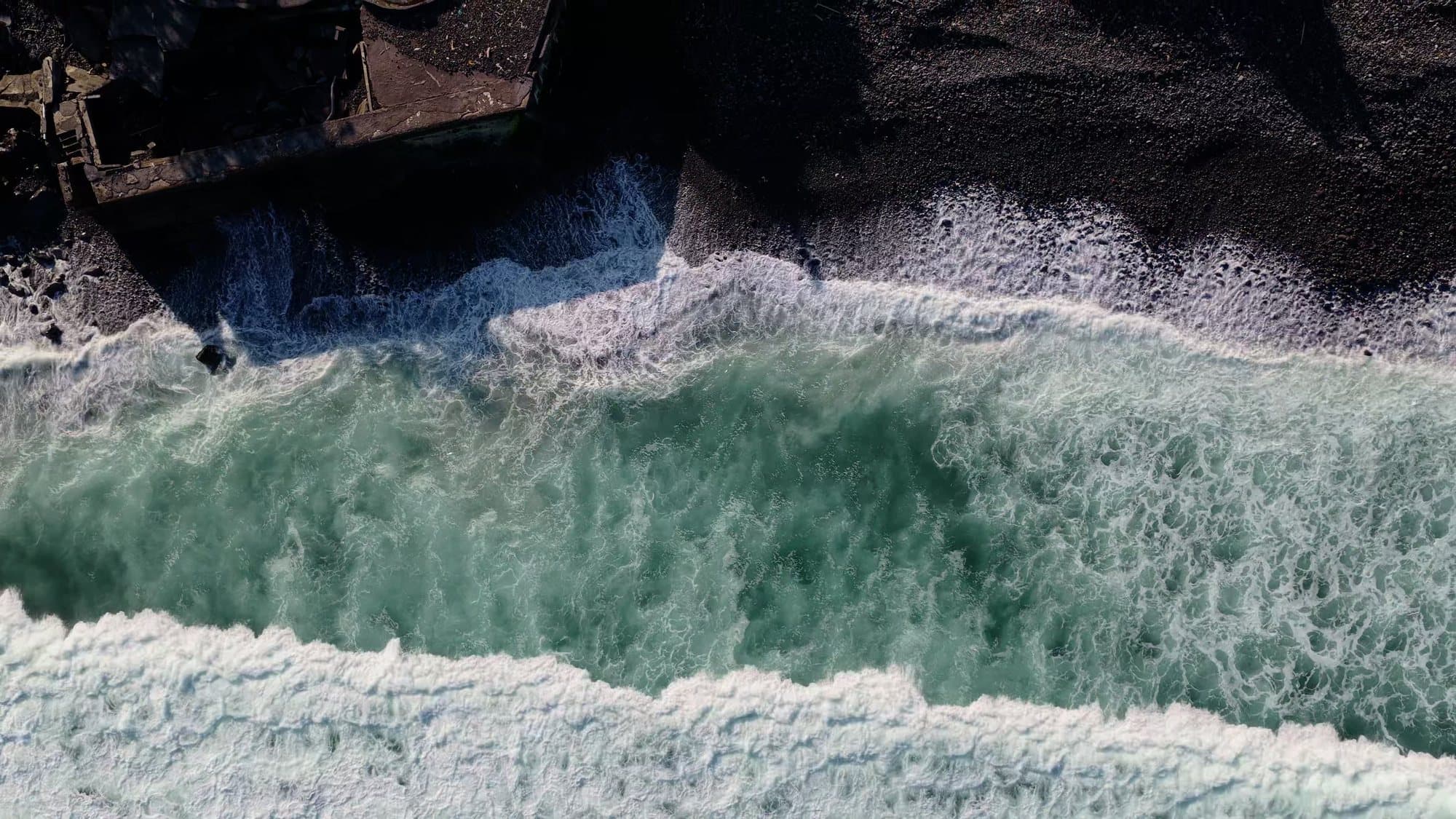 Surf on the black rocks of Candidasa